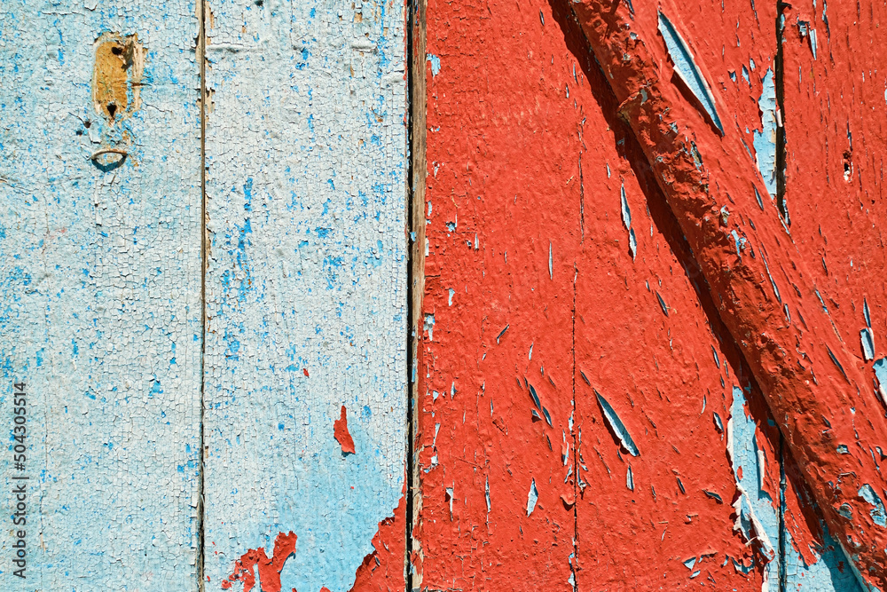 Old wooden wall with peeling red and blue paint, background for design or social media.
