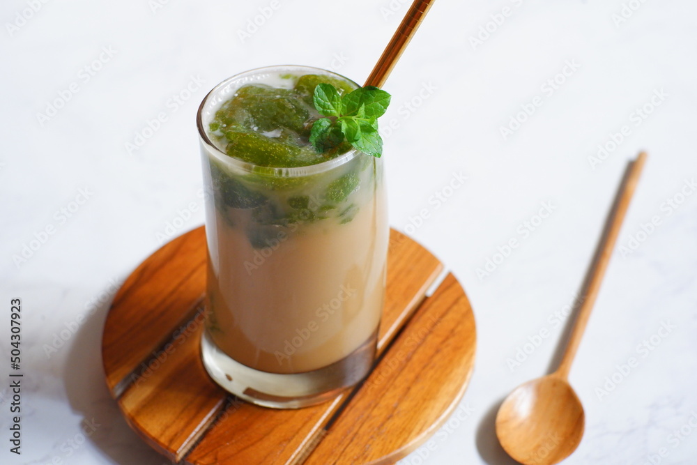 a glass of iced coffee with green grass jelly a glass of iced coffee with green grass jelly