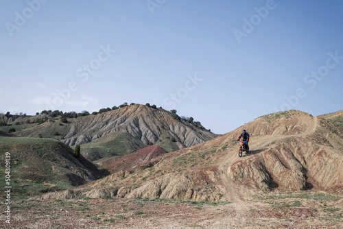 Motorcyclist travelling on offroad motorcycle on the top of canyon mountains