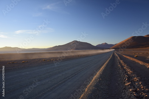 Sandy road through the desert at sunrise in Eduardo Avaroa National Reserve in Uyuni, Bolivia. photo
