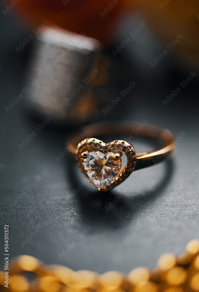 A diamond engagement ring on the black table