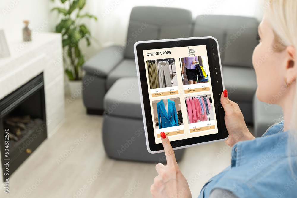 Woman looking for new clothes in online store on digital tablet Woman looking for new clothes in online store on digital tablet