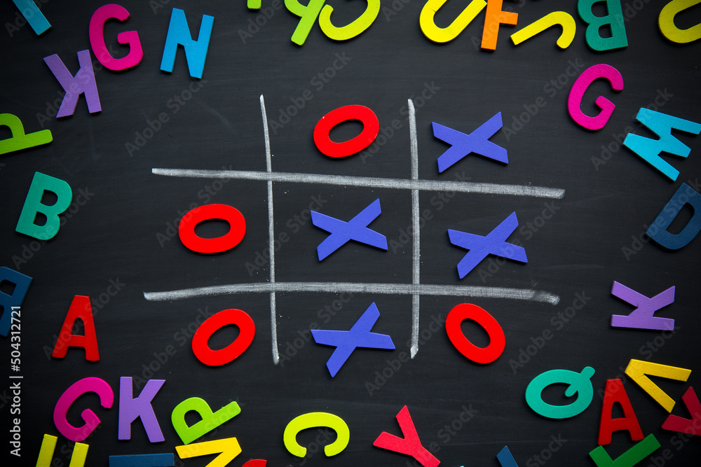 Abstract Tic Tac Toe Game Competition with Wood Alphabet letters. XO Win Challenge Concept on black board. Abstract Tic Tac Toe Game Competition with Wood Alphabet letters. XO Win Challenge Concept on black board.