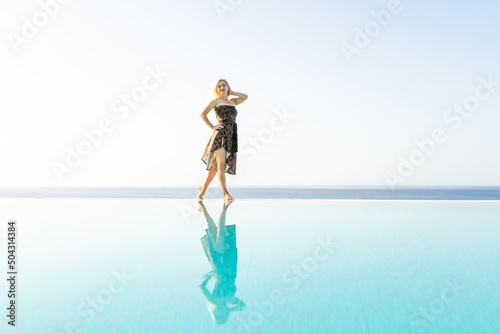 woman near the pool. By Swimming Pool On Travel Holidays Vacation. Beauty, Wellness, Lifestyle