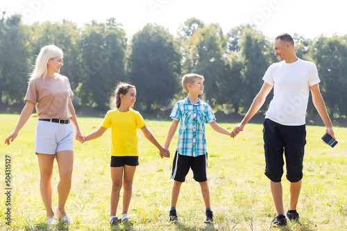 Fototapeta Naklejka Na Ścianę i Meble -  Happy family enjoying life together at meadow outdoor.