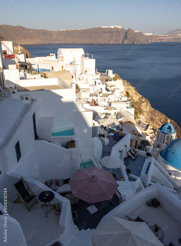  Whitewashed houses with terraces and pools and a beautiful view in Oia on Santorini island, Greece