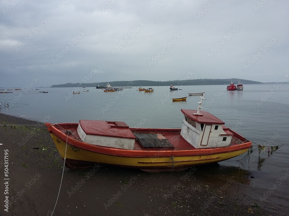 QUELLON, CHILE. Colourful fishing boats in the coastal town of Quellon on the island of Chiloe in Chile QUELLON, CHILE. Colourful fishing boats in the coastal town of Quellon on the island of Chiloe in Chile