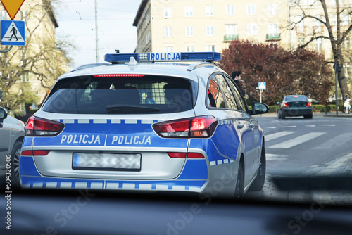 Policjant policji drogowej podczas nadzoru ruchu drogowego z radiowozem. 