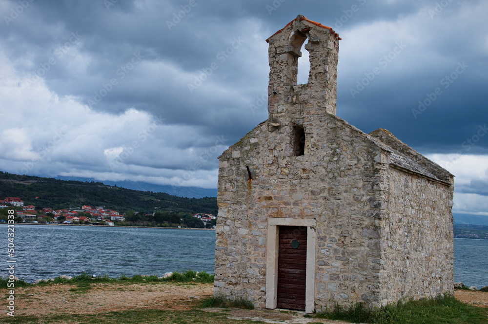 Little medieval stone church on rainy day