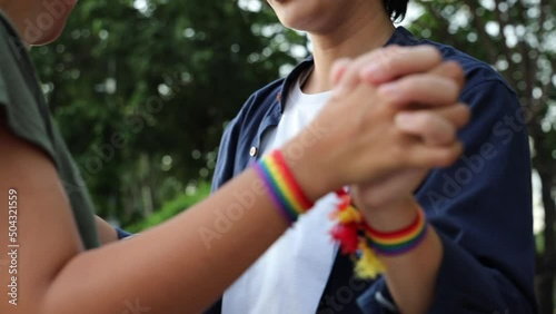 Non-binary LGBT people holding hand together with rainbow ribbon symbol, concept of LGBT pride, LGBTQ people, lgbt rights awareness campaign, same sex marriage