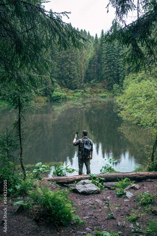 strong man hiker looking at mountain lake strong man hiker looking at mountain lake