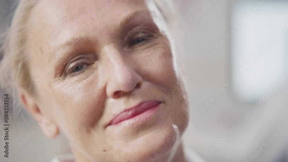 Close up of mature doctor remove safety mask and cap smiling at camera. Realtime Close up of mature doctor remove safety mask and cap smiling at camera. Realtime