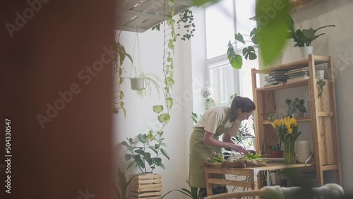 Gardener's office. Care of plants and flowers. Florist's shop, woman seller creates a bouquet