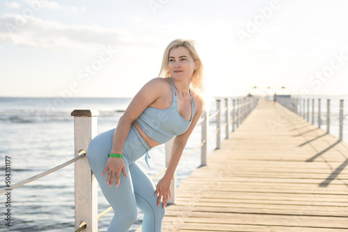 Fototapeta Naklejka Na Ścianę i Meble -  Young beautiful sportive girl training at sunrise over seaside.