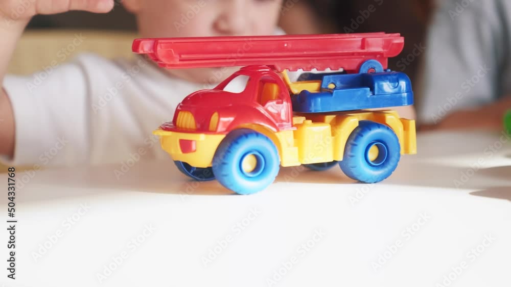 little boy and baby girl play in kindergarten. a group of children play toys cubes and indoor cars on the table in kindergarten. happy family preschool education concept. nursery baby toddler home little boy and baby girl play in kindergarten. a group of children play toys cubes and indoor cars on the table in kindergarten. happy family preschool education concept. nursery baby toddler home