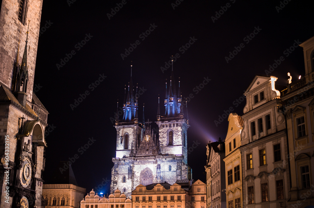 gothic church towers on central square from the side of the Charles Bridge of Prague city at night