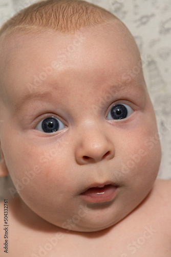 close-up portrait of a three-month-old baby with blue eyes