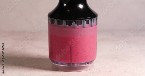 Mixing raspberry and milk in blender smoothy preparation