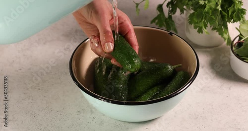 Fresh green cucumber vegetable fruit in white bowl washing