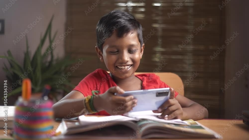 Asian boy 8-10 years old using a smartphone, playing online games Asian boy 8-10 years old using a smartphone, playing online games