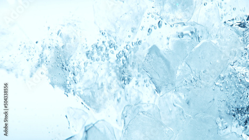 Close up of ice cubes underwater, blue background.