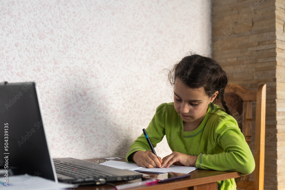 Smiling little Caucasian girl in headphones have video call distant class with teacher using laptop, happy small child wave greeting with tutor, study online on computer, homeschooling concept Smiling little Caucasian girl in headphones have video call distant class with teacher using laptop, happy small child wave greeting with tutor, study online on computer, homeschooling concept