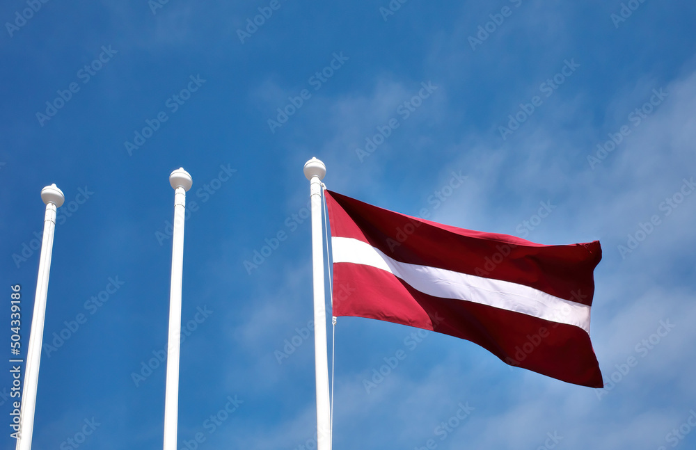 Flag of the Republic of Latvia and three flagpoles.