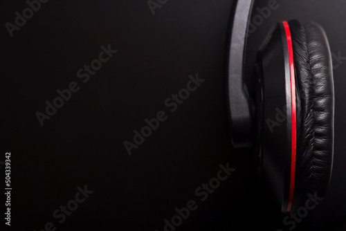 Black and red headphones on a dark background with copyspace