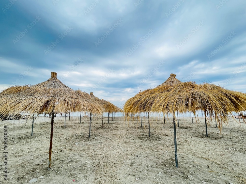 Straw beach umbrellas on a blue sky and sea background.Copy space 