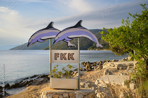 Fototapeta Naklejka Na Ścianę i Meble -  Sign with two dolphins showing the beginning of the nudist beach