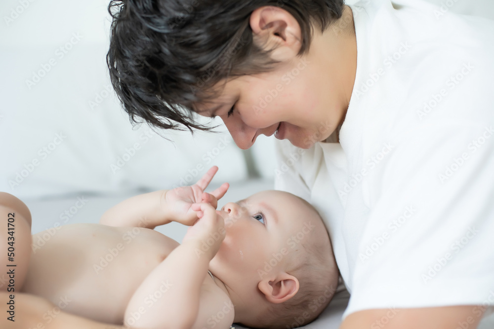 A young mother is holding her newborn baby. Mother of a nursing baby. Mother breastfeeding her baby. The family is at home. Portrait of a happy mother and child A young mother is holding her newborn baby. Mother of a nursing baby. Mother breastfeeding her baby. The family is at home. Portrait of a happy mother and child