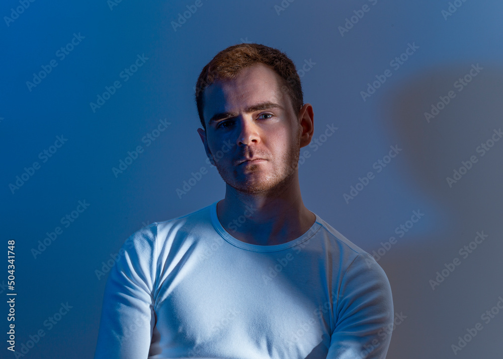 Fototapeta premium Contemporary young man posing in various poses in studio.Futuristic neon lighting.Portrait photo shoot.