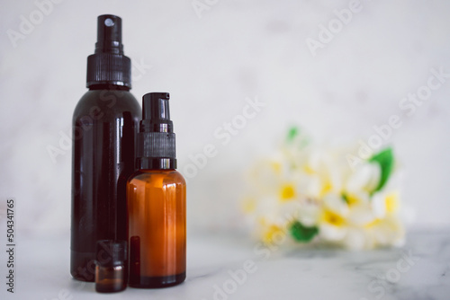 natural beauty and organic ingredients in skincare, apothecary skincare bottles with tropical flowers bokeh