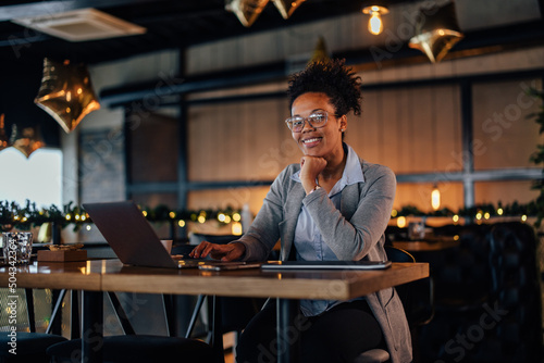 Portrait of a joyful African-American bar owner, pleased with her business.