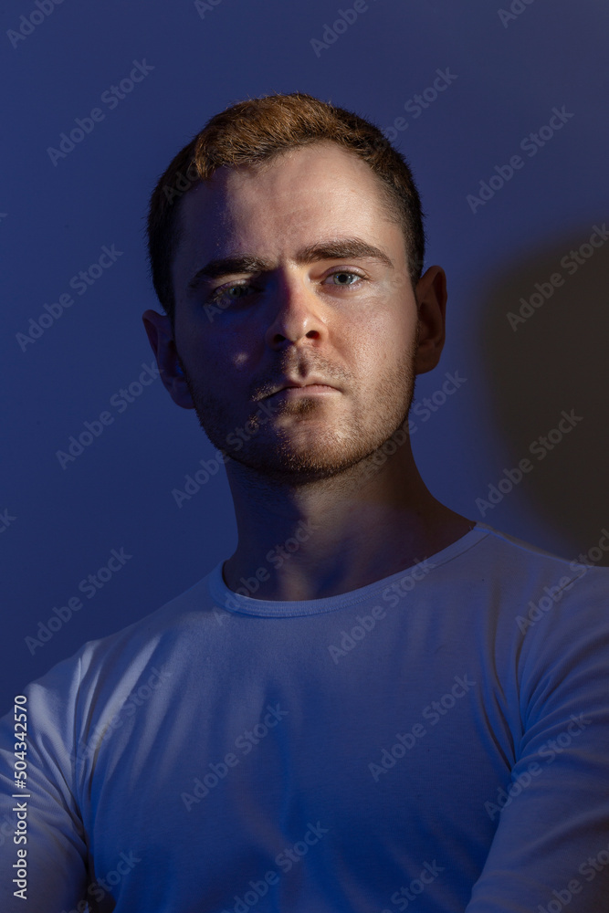 Contemporary young man posing in various poses in studio.Futuristic neon lighting.Portrait photo shoot.