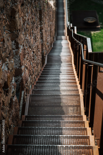 Fototapeta Naklejka Na Ścianę i Meble -  Viele Treppenstufen an einer Mauer entlang, mit Geländer. mit Perspektive von Schärfe im Vordergrund zur Unschärfe