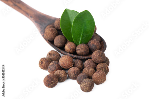Pile of allspice isolated on white background. Jamaica pepper, allspice peppercorns or myrtle pepper in a wooden spoon.