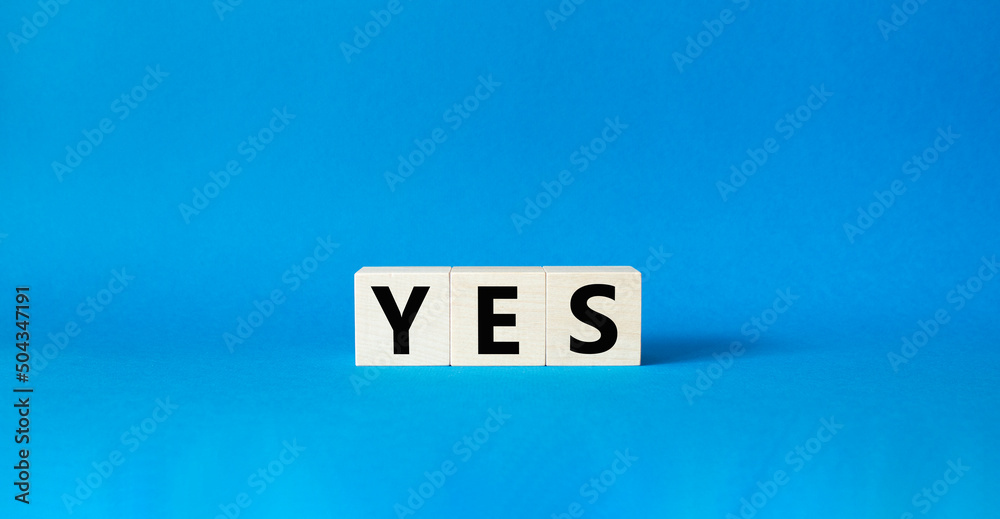 Yes symbol. Wooden blocks with word yes. Beautiful blue background. Business and yes concept. Copy space. Yes symbol. Wooden blocks with word yes. Beautiful blue background. Business and yes concept. Copy space.