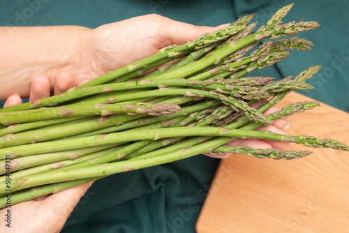 Female hands holding asparagus and cooking