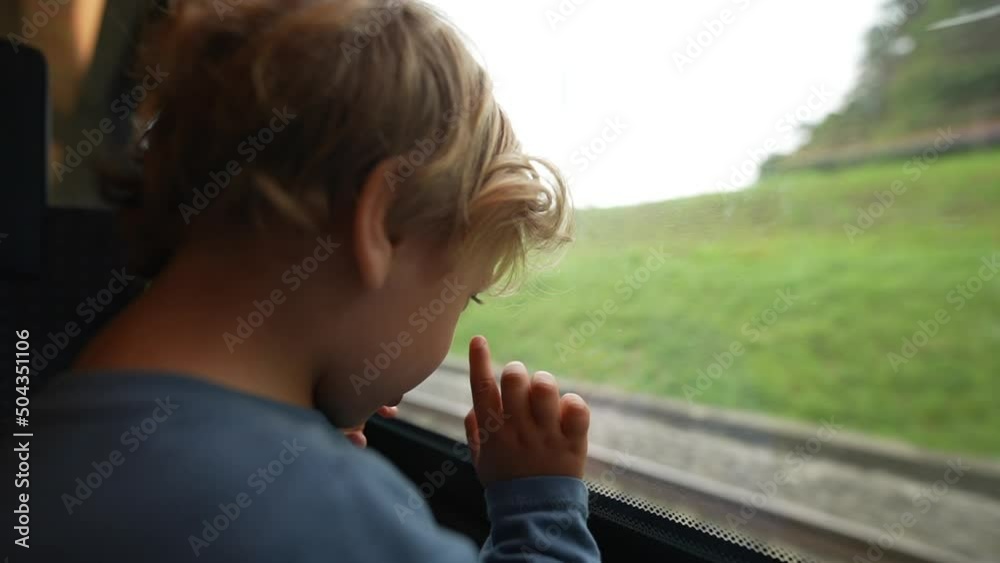 Kid travels by train standing by window Kid travels by train standing by window