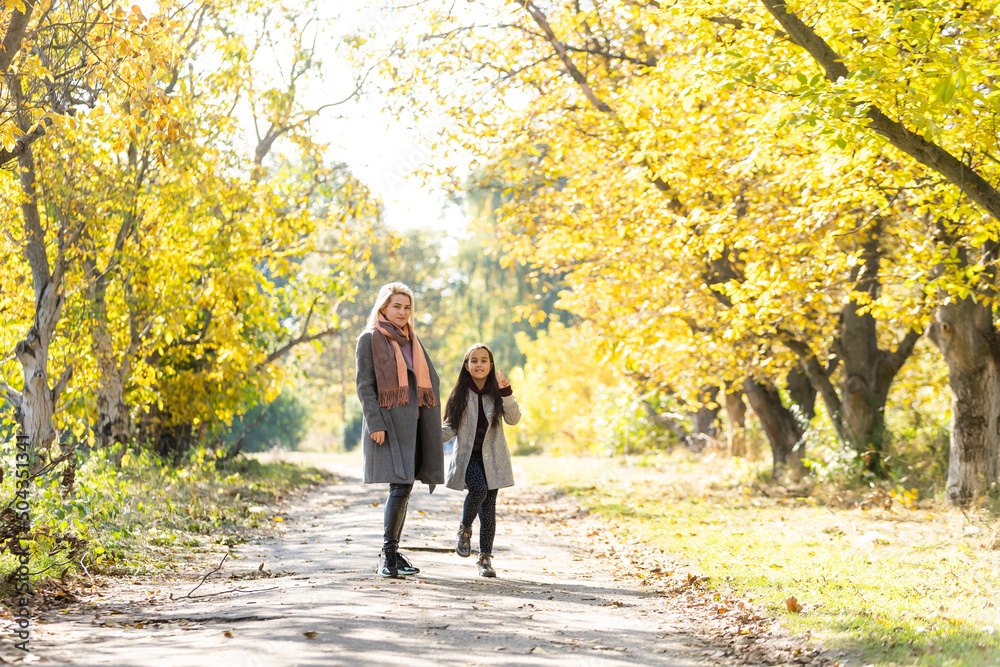 Young mother playing with her daughter in autumn park Young mother playing with her daughter in autumn park