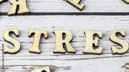 Stress - word from wooden blocks with letters, great worry caused by a difficult situation stress concept, random letters around white background