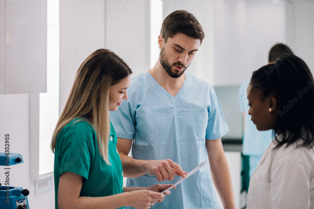 Obraz premium Multiracial team of doctors discussing a patients condition while working in a hospital