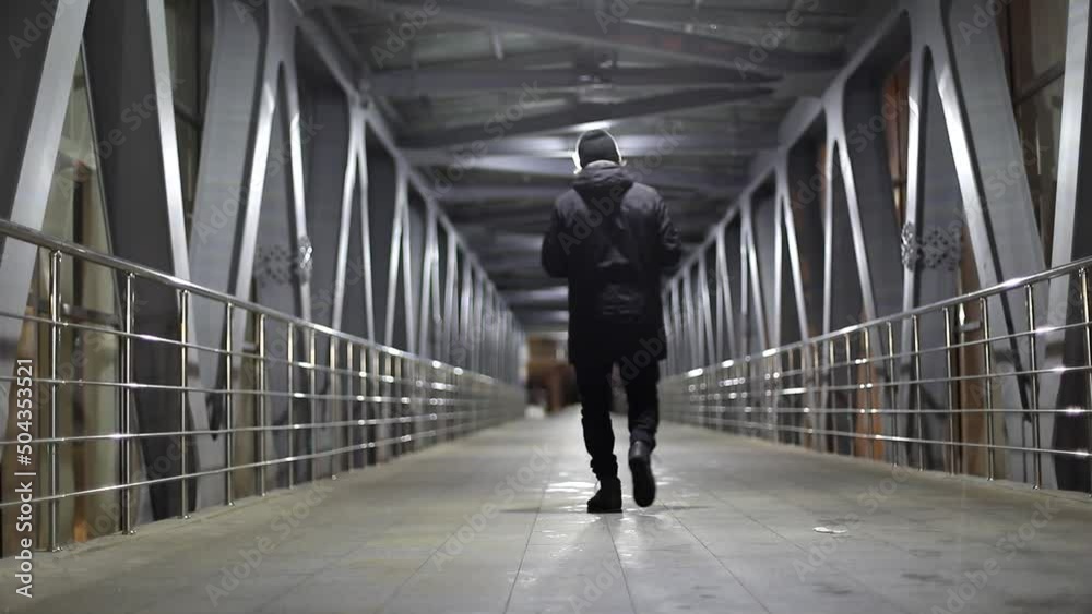 Bridge across road. Pedestrian area. Light in tunnel. Man walks inside tunnel. Bridge across road. Pedestrian area. Light in tunnel. Man walks inside tunnel.
