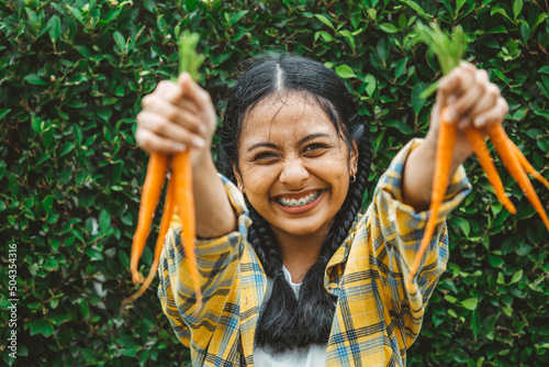 eating vegan vegetable for healthy good for life concept. young teen hand holding baby carrot happy smile.