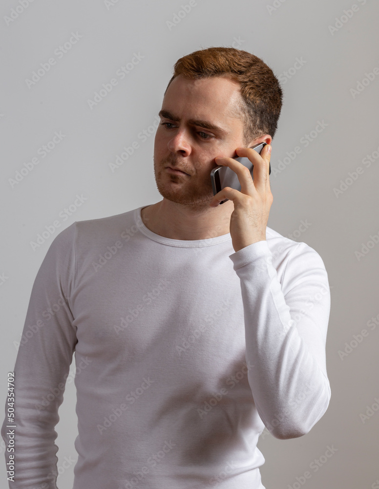Contemporary young man poses in studio.Talking on the phone. Contemporary young man poses in studio.Talking on the phone.