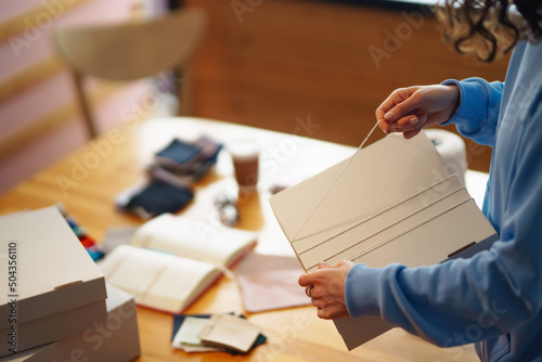 Preparing a parcel on the table. Оnline store, small business owner, seller, entrepreneur, packing bag, mailbox, preparing a parcel on the table. Dropshipping delivery concept in e-commerce.