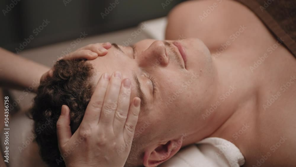chiropractor is curing headache of male patient, massaging head by hands, manual therapy for health and relax