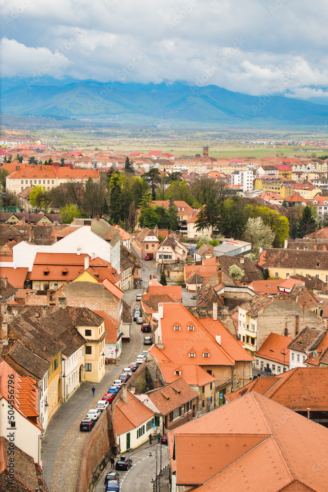 Obraz premium Aerial cityscape of historic Sibiu city in Transilvania, Romania, and cloudy Carpathian mountains 