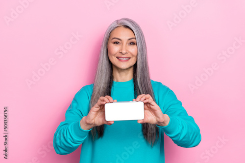 Photo of pretty glad person hold demonstrate empty space display promo isolated on pink color background